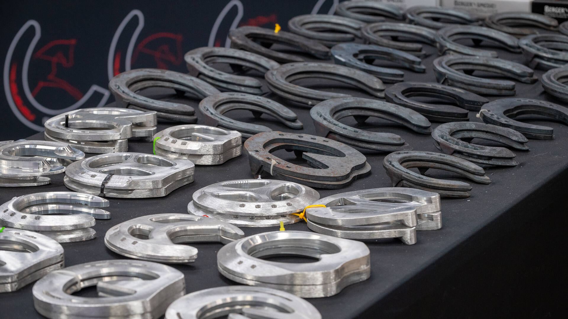 A bench of handmade and machined horseshoes at a farriery demonstration